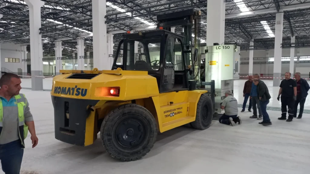 Fabrika içinde çalışan sarı Komatsu forklift
